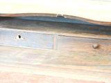 a wooden bench with drawers underneath it on a wooden floor