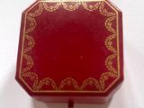 une petite boîte rouge ornée d'un motif doré