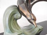 a bronze sculpture of a dolphin on a wave