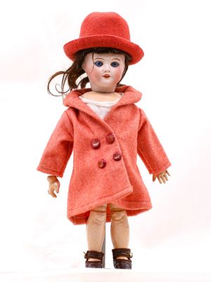une poupée qui porte un manteau rouge et un chapeau rouge