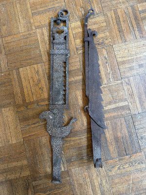 pair of old iron door handles on a wooden floor