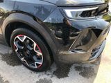 a close up of a black suv parked on the side of the road