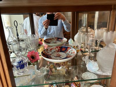 un homme en train de prendre une photo d'une vitrine remplie d'objets en verre