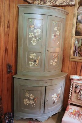 a corner cabinet in the corner of a room