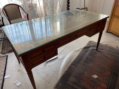 a desk with a glass top in a living room