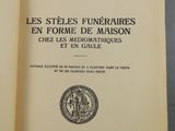 un livre ouvert posé sur une table, à côté d'un verre