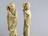 paire de figurines en ivoire sculpté représentant deux femmes et une poire