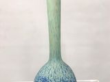 un vase bleu et vert exposé dans une vitrine