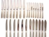 an assortment of silverplated knives and knives on a white surface