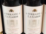 three bottles of red wine are lined up on a table