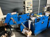 two blue machines are sitting in a warehouse with boxes and boxes