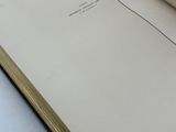 an open book sitting on top of a white table next to a cup of coffee