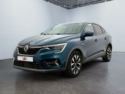 Une voiture bleue est garée dans une grande pièce aux murs blancs.