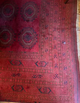 an image of a red rug on a wooden floor next to a window