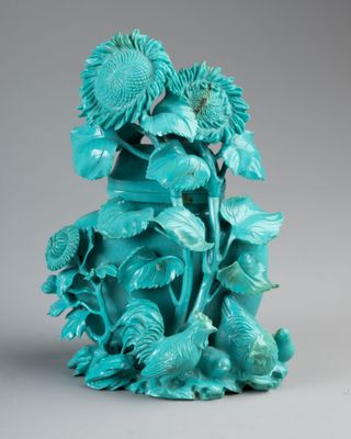 une image représentant un vase bleu orné de fleurs et de feuilles