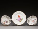 trois assiettes et un bol décorés de fleurs, posés sur une table