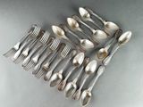 a lot of spoons and forks arranged together on a table