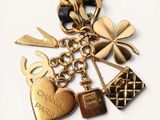 a gold chain with charms on it that says chanel