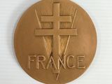 gold medal with the word france on it and a cross in the center