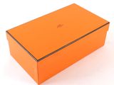 an orange box on a white surface with a black lid