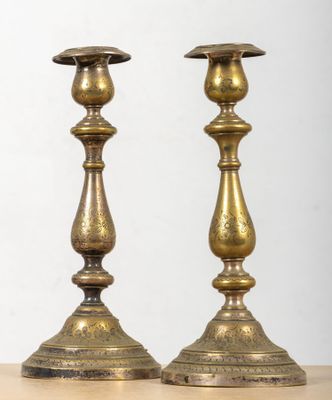 pair of antique brass candlesticks on a wooden table