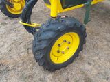 a small yellow tractor with a big tire on the ground