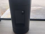 a black trash can sitting in front of a window