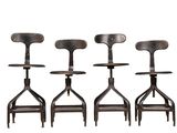three black metal stools sitting next to each other on a white surface