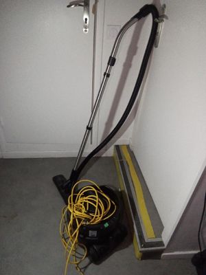 un aspirateur posé sur le sol à côté d'une porte