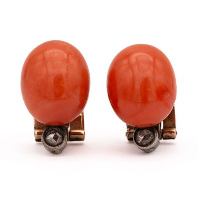 une paire de boucles d'oreilles en corail rouge et argent sur fond blanc