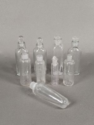 several empty glass bottles sitting on top of a gray surface