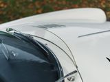 a close up of a white sports car parked on the side of the road