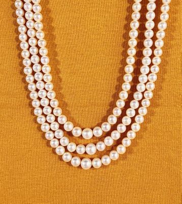 un gros plan d'un collier de perles sur fond jaune