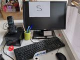 un bureau d'ordinateur sur lequel se trouvent un clavier, une souris et un téléphone