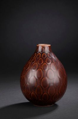 brown and black vase on a black background with a black background