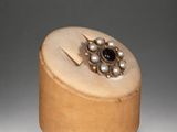 a wooden box with a ring on top of it