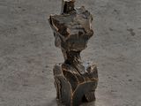 une sculpture représentant un homme assis sur un rocher