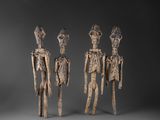 a group of three carved wooden figures standing next to each other