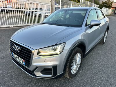 a silver audi qx parked in front of a white fence