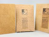 deux livres marron ouverts, posés l'un sur l'autre sur une table
