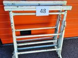 un présentoir en métal blanc portant le numéro 48, devant un mur orange