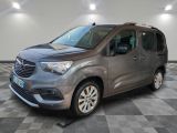 La camionnette grise est garée sur un sol en carrelage à damier.