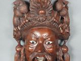 une image représentant un masque en bois sculpté orné d'oiseaux
