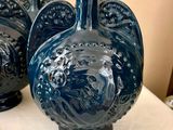 trois vases bleus posés les uns à côté des autres sur une table