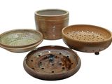 three bowls and a strainer on a white background