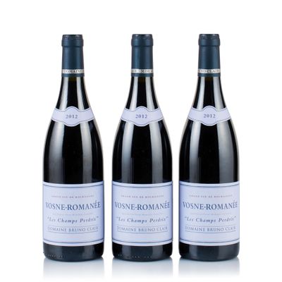 three bottles of wine sit side by side on a white surface