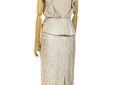 a mannequin wearing a white dress on a wooden stand