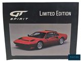 the box of a red sports car is sitting on a white surface
