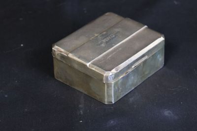 a small silver box on a black surface