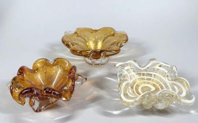 trois morceaux de verre empilés les uns sur les autres sur une surface blanche